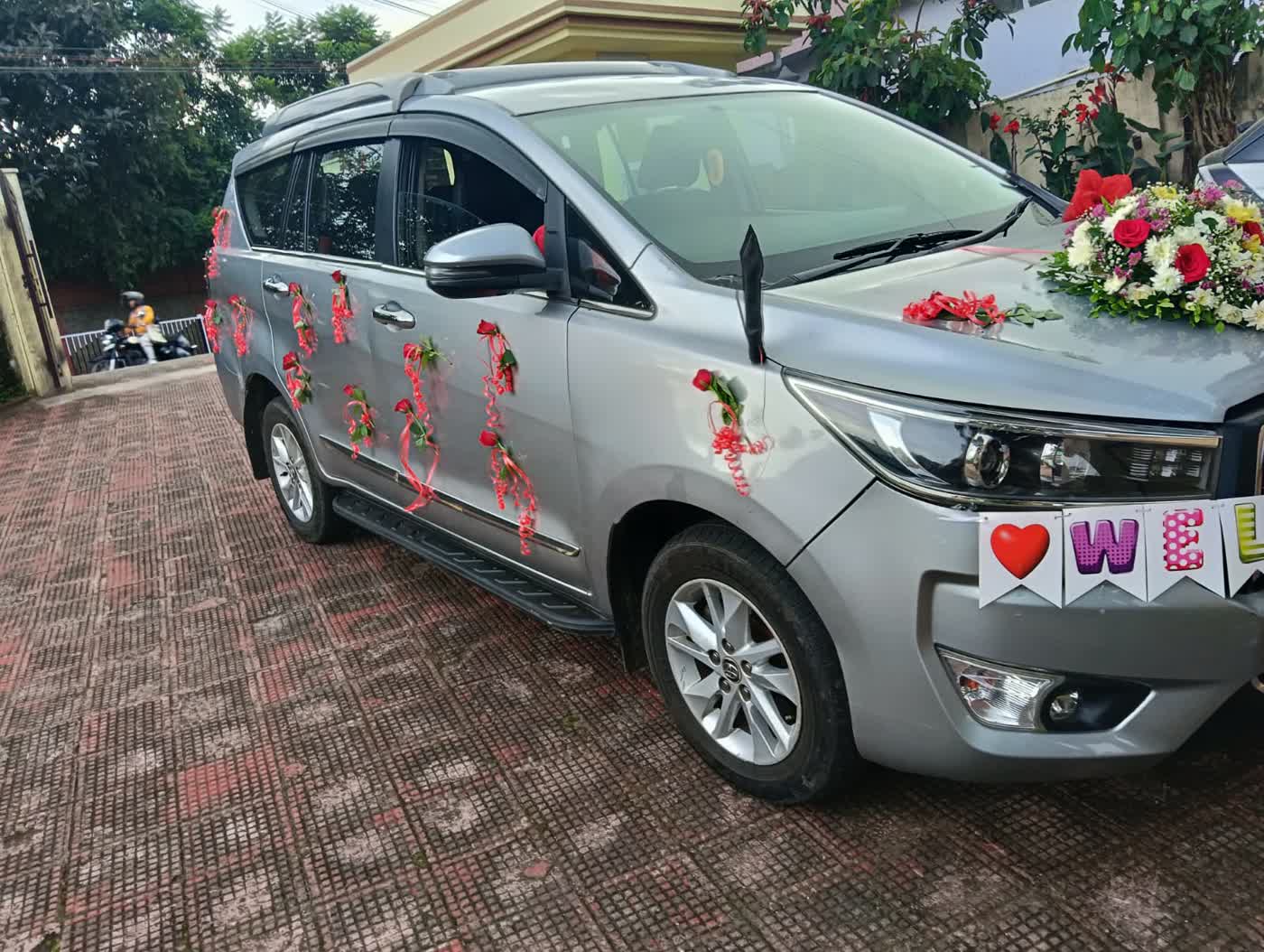 Innova decorated with roses and ribbons for a wedding pickup in Shillong